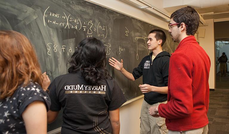 Students studying on a chalk board.