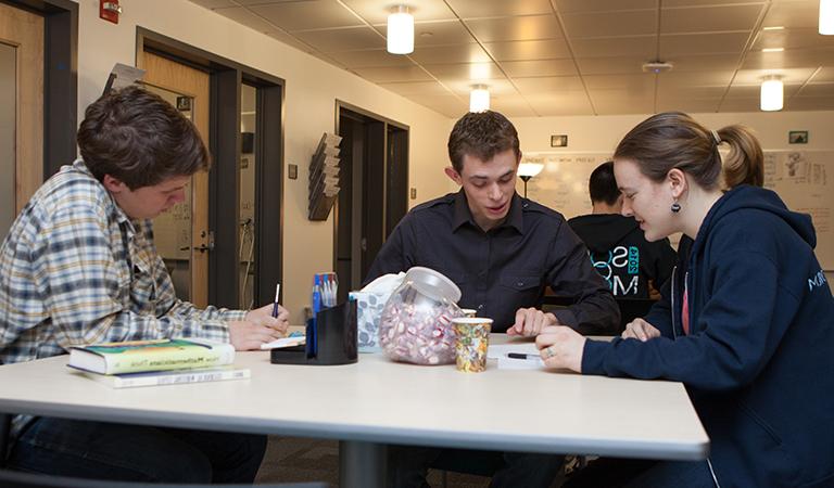 Students at a table in the Writing Center.